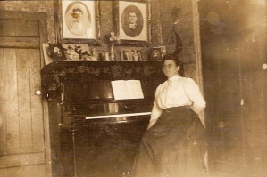 The proud owner of a new piano, purchased from a piano wagon out of Portland, Oregon. Photographs of her wedding to Karl (Charles) Kuhnhausen grace the top of the piano. This piano sits in my music room.